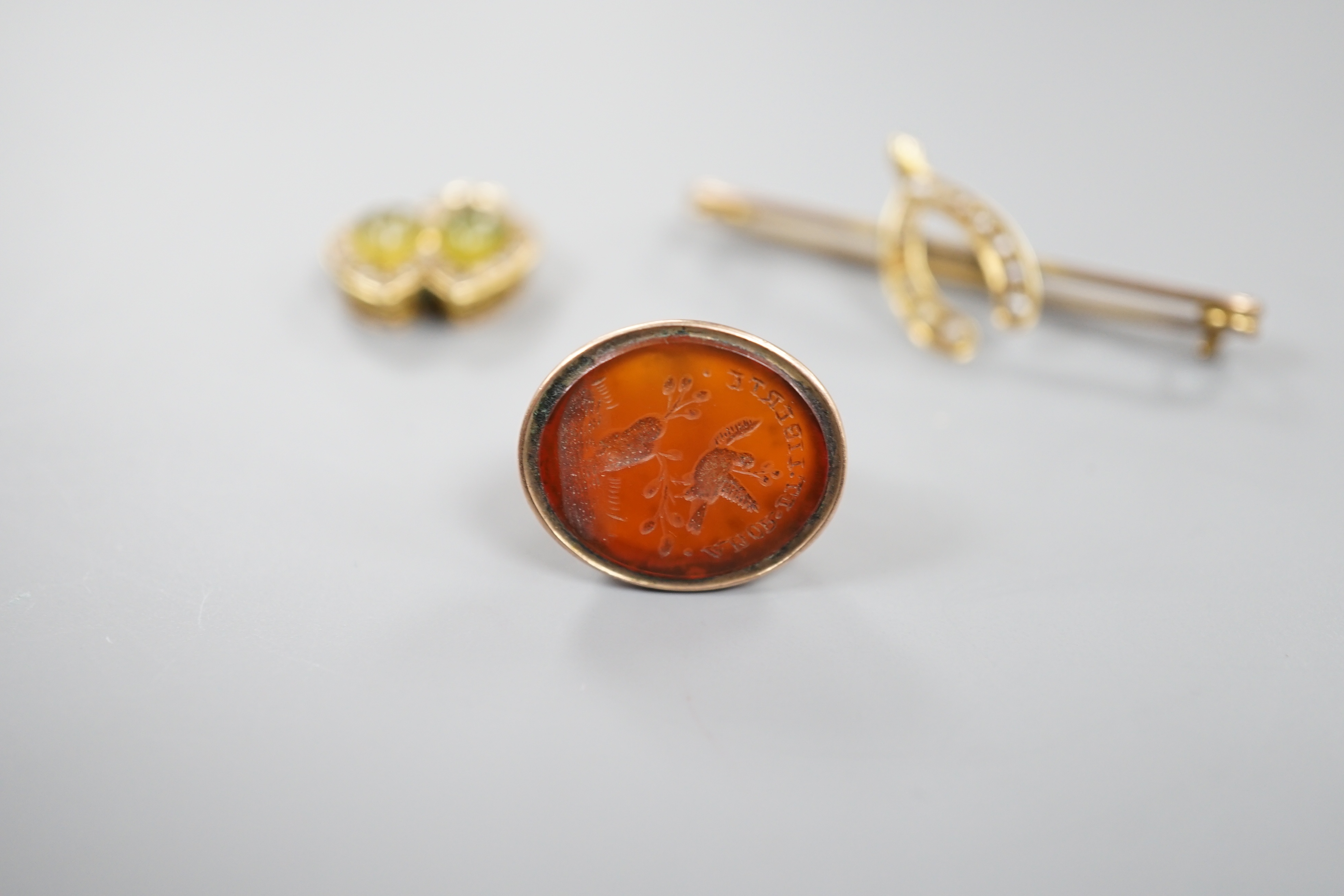 A yellow metal olivine? and seed pearl set twin heart pendant, width 15mm, a 19th century carnelian set fob seal and a wishbone bar brooch.